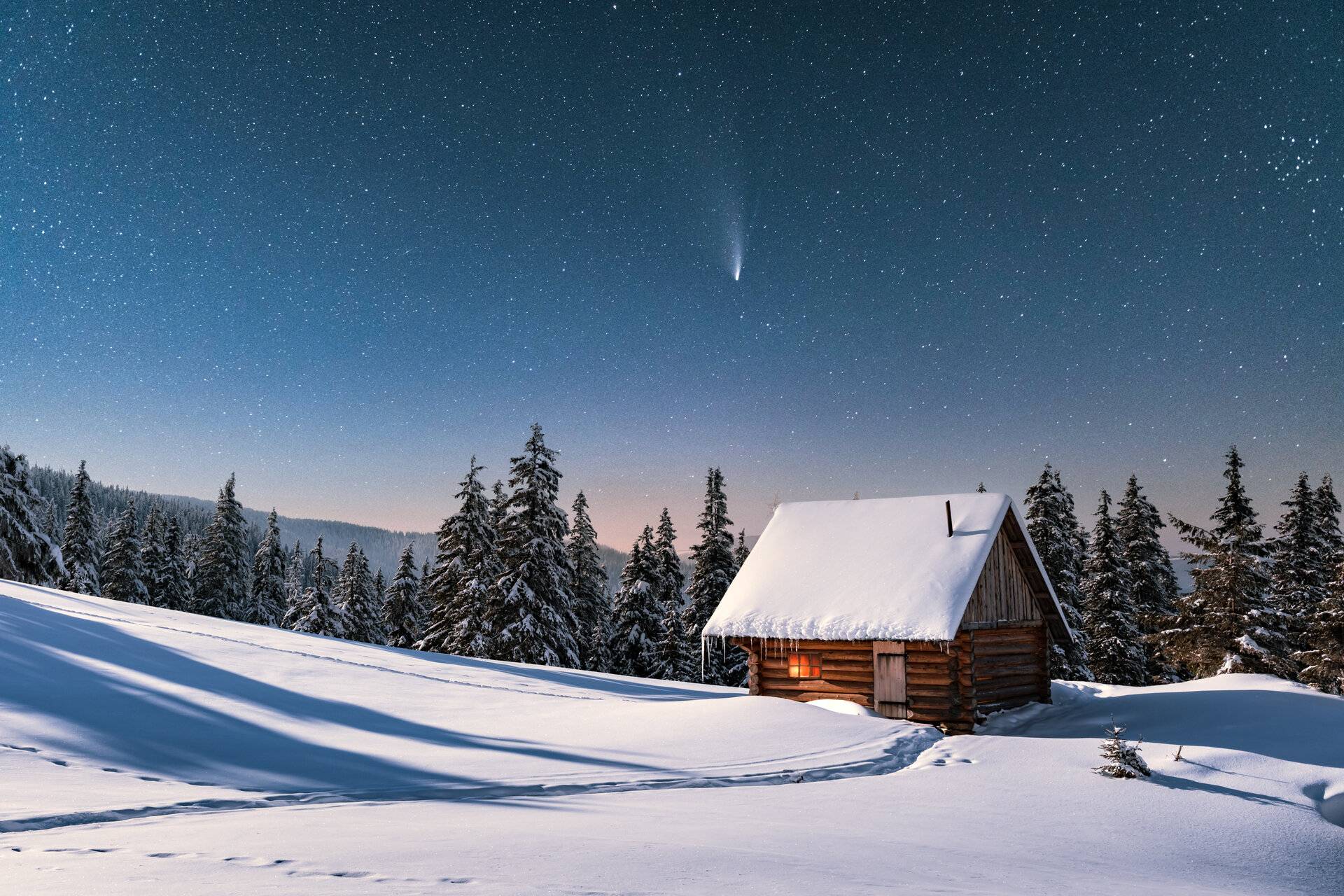 Fantastische Winterlandschaft mit Holzhaus in schneebedeckten Bergen. Sternenhimmel mit Komet und schneebedeckter Hütte. 