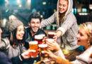 Fröhliche Menschen trinken Bier in der Brauereibar im Freien