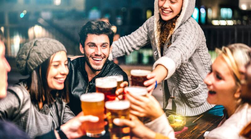 Fröhliche Menschen trinken Bier in der Brauereibar im Freien