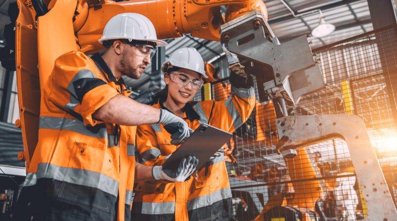 Ingenieur Team Service Roboter Schweißen arbeiten in der Automatisierung Fabrik. Menschen Arbeiter in Sicherheitsanzug Arbeit Roboterarm Software-Programmierung oder Ersetzen von Teil in automatisierten Fertigungsindustrie Technologie.