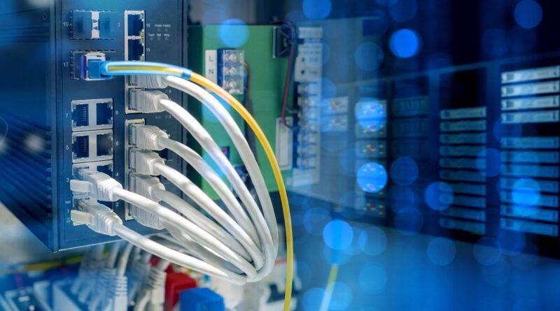 Industrieller Ethernet-Switch mit mehreren angeschlossenen Netzwerkkabeln in einem Schaltschrank