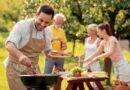 Familie grillt gemeinsam an Outdoor Küche