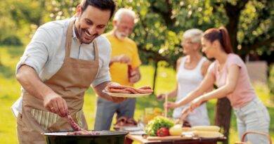 Familie grillt gemeinsam an Outdoor Küche