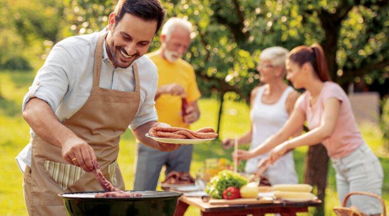 Familie grillt gemeinsam an Outdoor Küche