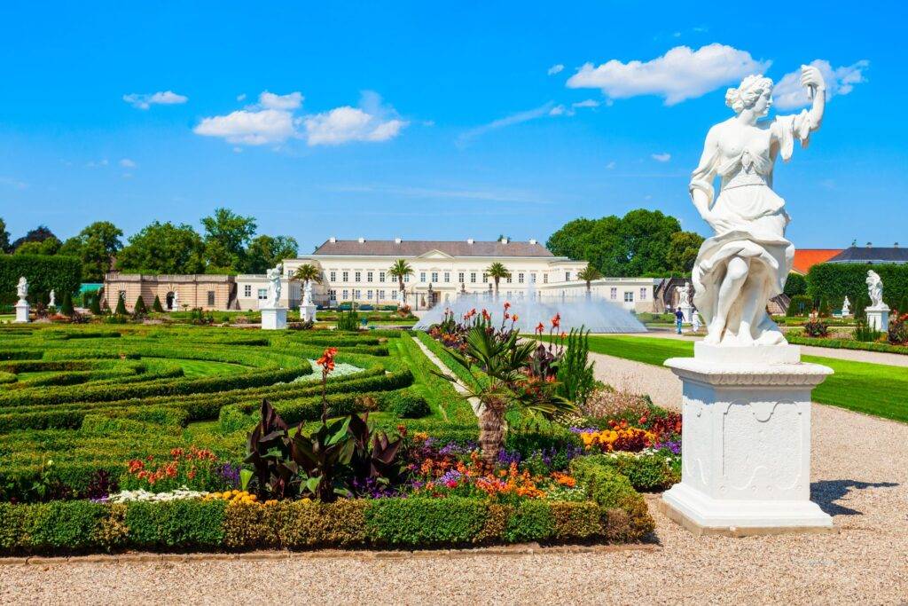 Barockgarten und Schloss in den Herrenhaeuser Gaerten Hannover bei blauem Himmel