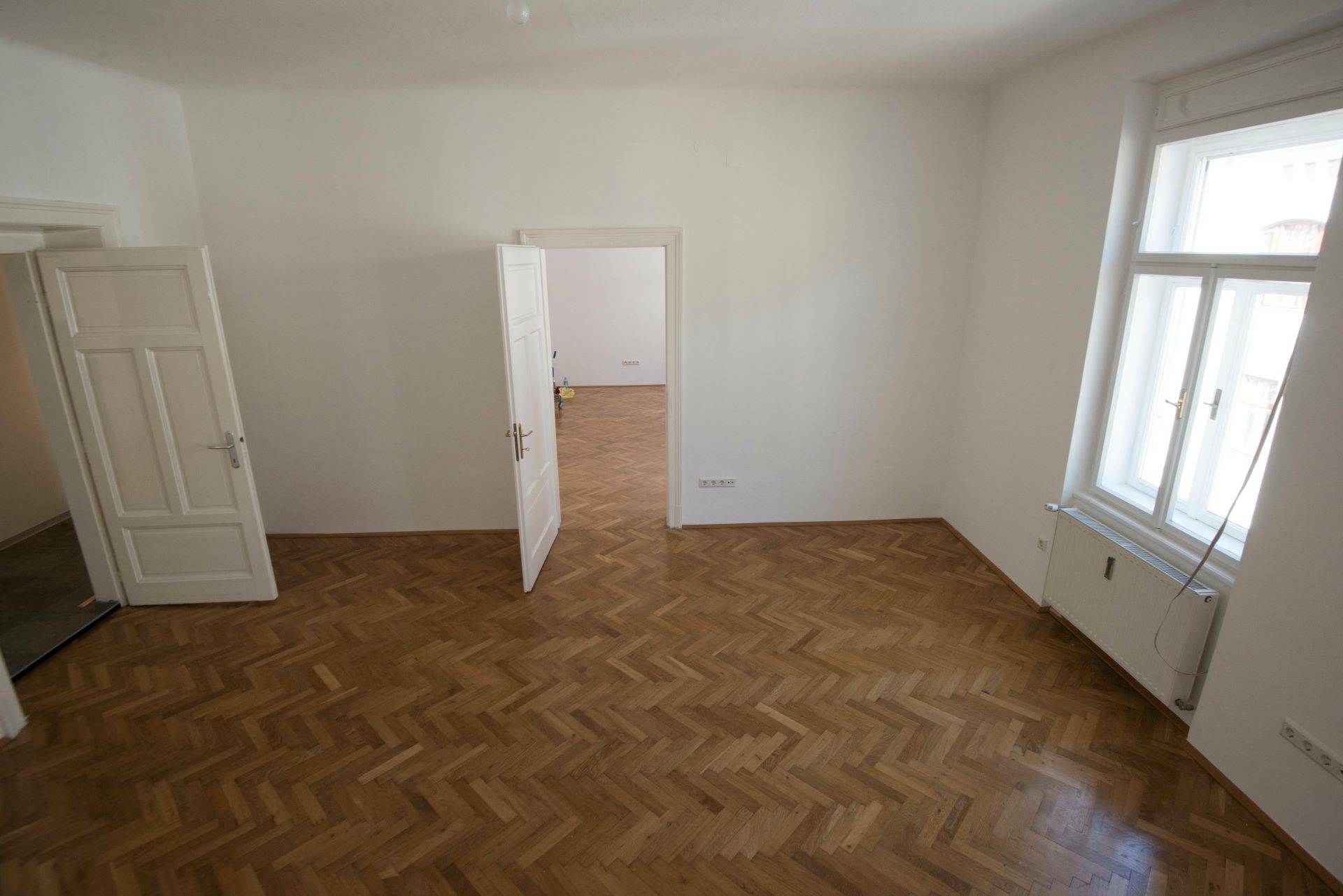 Besenreine Wohnung nach erfolgreicher Haushaltsaufloesung in Oberhausen – leerer Raum mit Parkett und geoeffneten Zimmertueren

