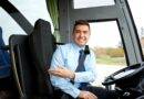 Busfahrer lächelt im Fahrersitz eines Stadtbusses