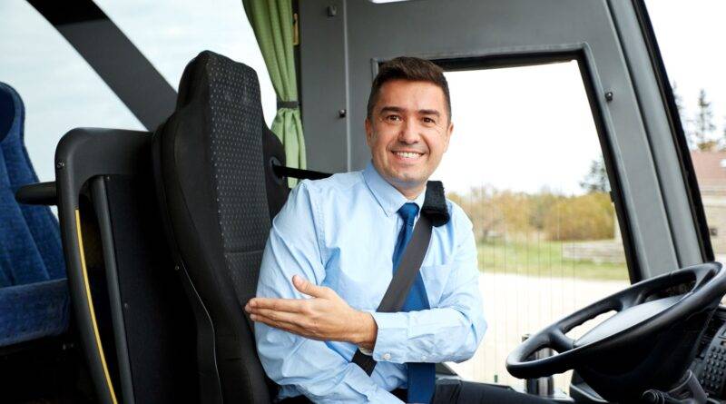 Busfahrer lächelt im Fahrersitz eines Stadtbusses