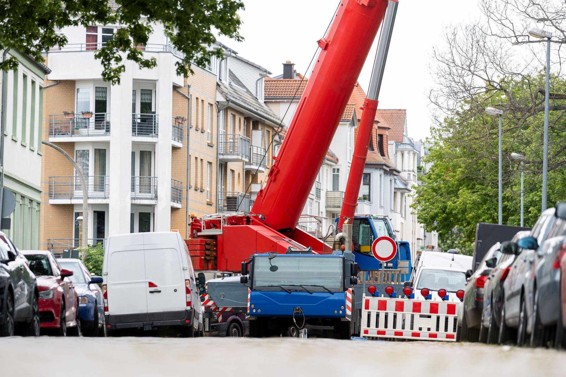 Großkran und Fahrzeuge in Oberhausener Wohnstraße bei Bauarbeiten