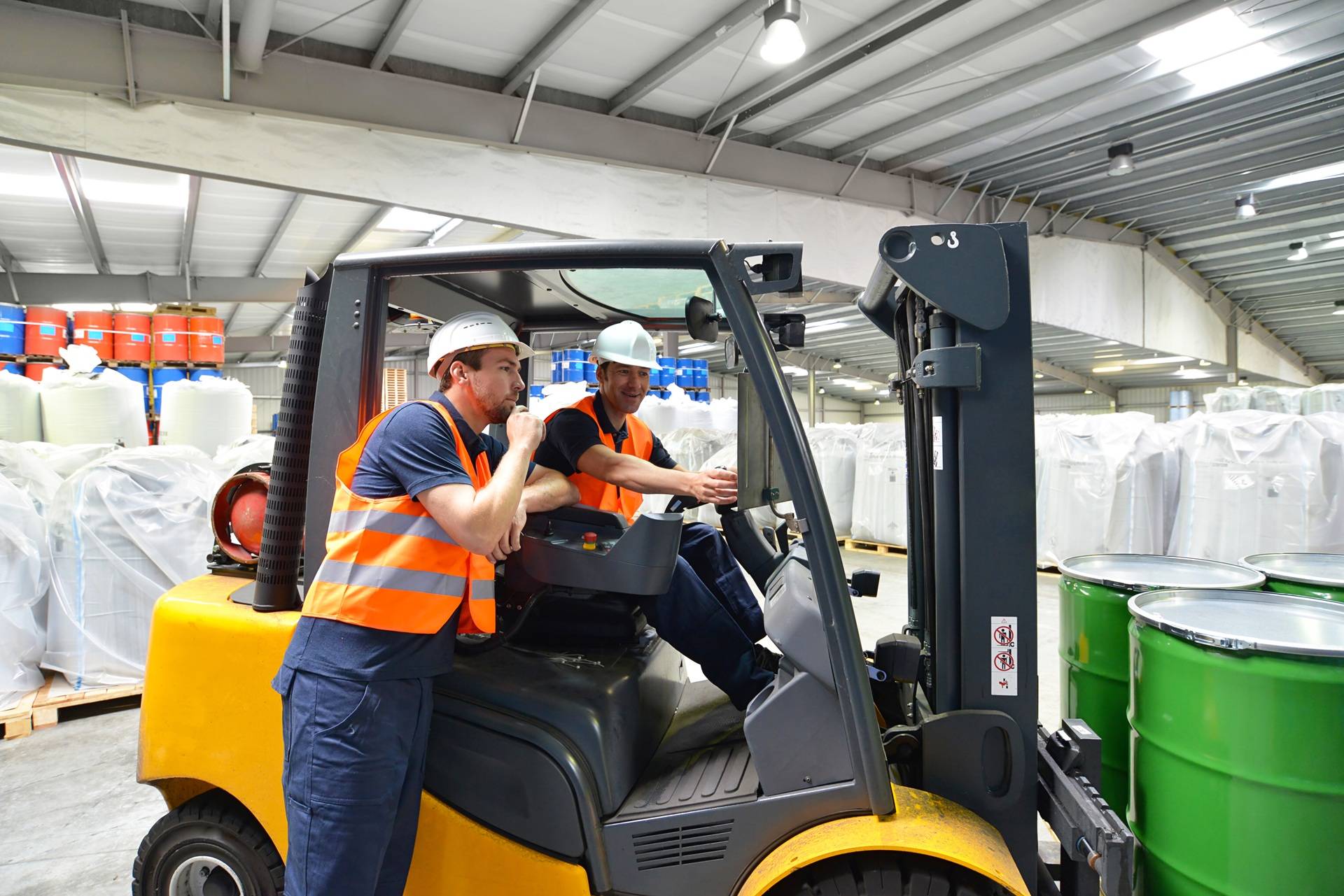 Zwei Arbeiter mit Gabelstapler in Industriehalle | mobiler Palettenwickler