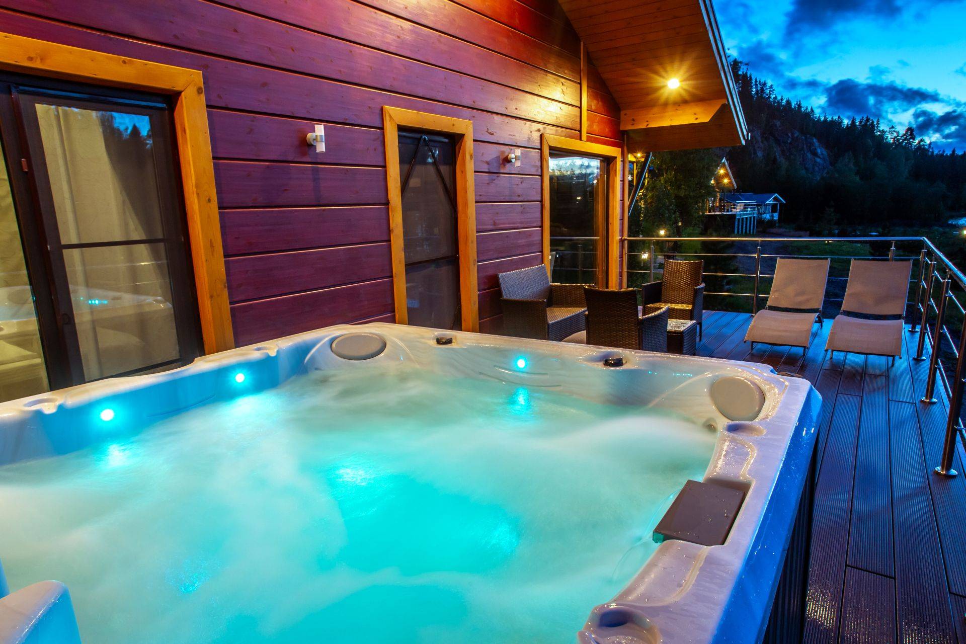 Whirlpool-Zubehoer auf Terrasse mit LED-Beleuchtung und Blick auf Wald bei Abenddaemmerung